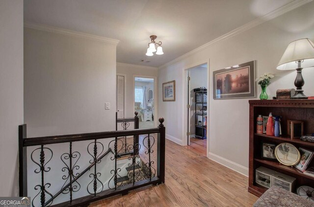 hallway featuring light wood-type flooring and ornamental molding