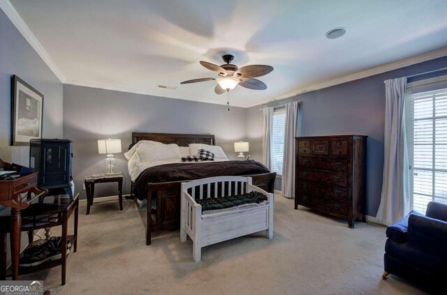 carpeted bedroom featuring ceiling fan and crown molding