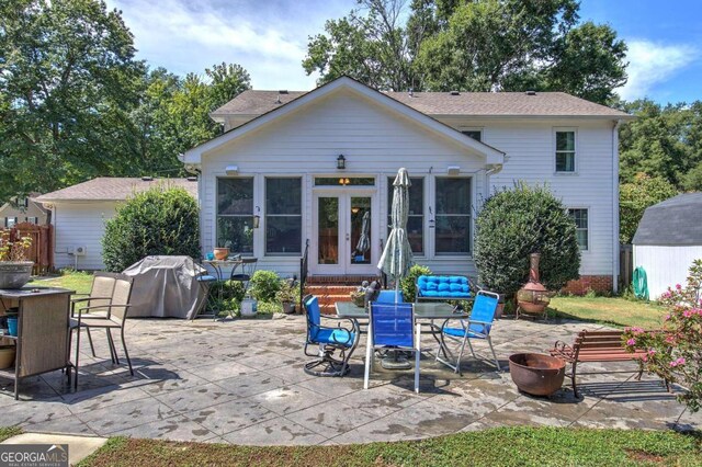 back of house with a fire pit, french doors, a shed, and a patio area