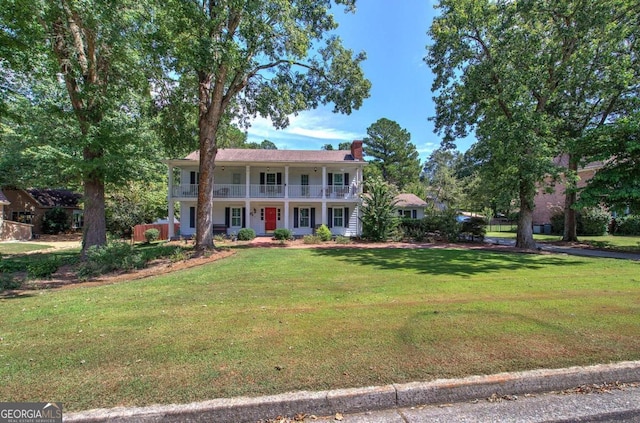 231 Parkview Dr, Cartersville, GA 30120 - colonial house featuring a front lawn, a balcony, a chimney, and covered porch