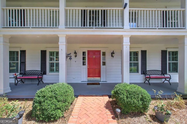 entrance to property featuring a balcony and covered porch