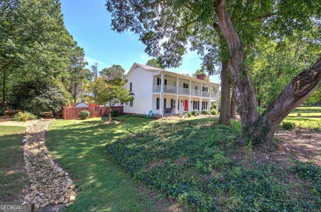 231 Parkview Dr, Cartersville, GA 30120 - colonial house with a chimney, covered porch, fence, a balcony, and a front yard