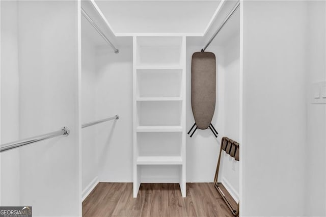 walk in closet with light hardwood / wood-style flooring