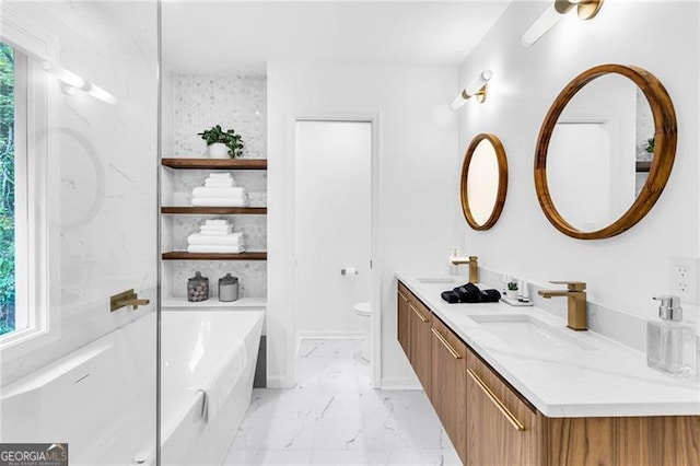 bathroom with vanity, toilet, a healthy amount of sunlight, and a bathtub