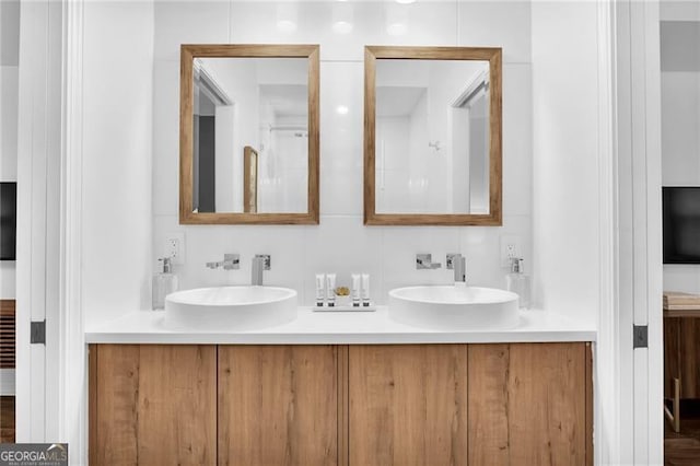 bathroom with vanity, hardwood / wood-style floors, and decorative backsplash