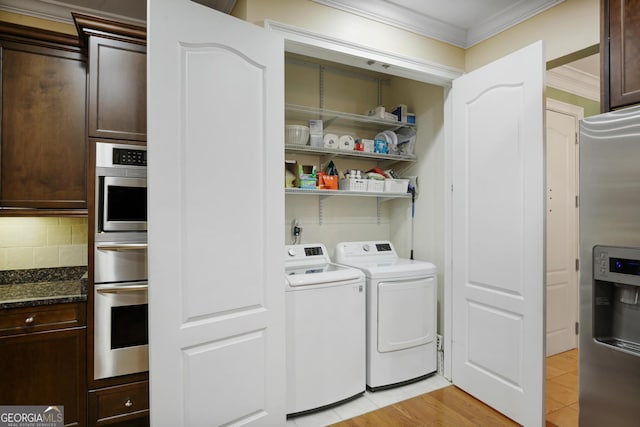 laundry area featuring ornamental molding, independent washer and dryer, and light wood-type flooring