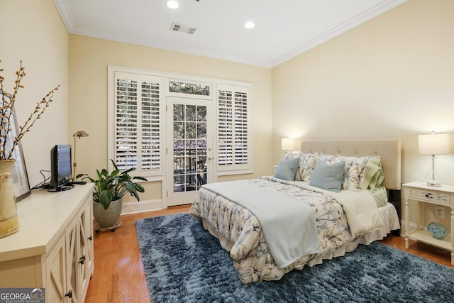 bedroom featuring multiple windows, hardwood / wood-style flooring, access to exterior, and crown molding