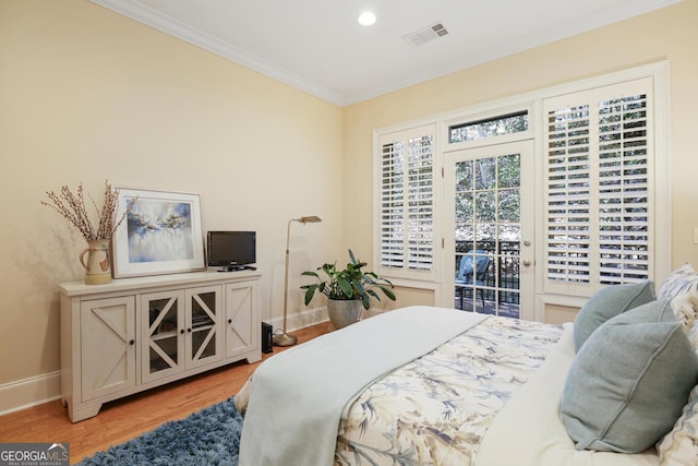 bedroom with light hardwood / wood-style floors, access to outside, and ornamental molding