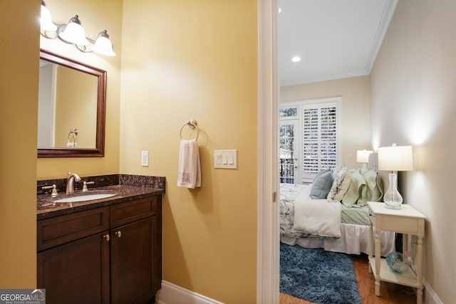 bathroom featuring crown molding, vanity, and hardwood / wood-style flooring