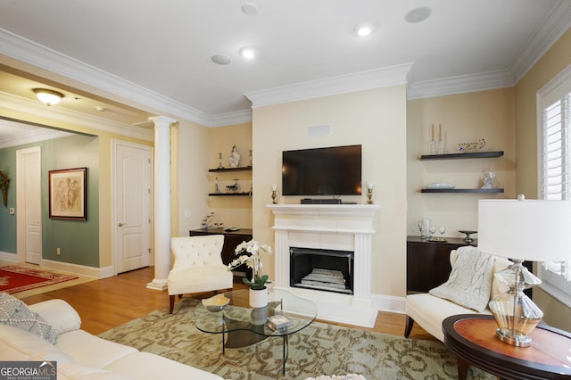 living room featuring crown molding, decorative columns, and light hardwood / wood-style floors