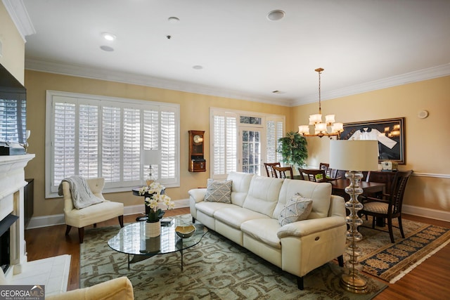 living room featuring dark hardwood / wood-style flooring, an inviting chandelier, crown molding, and a healthy amount of sunlight