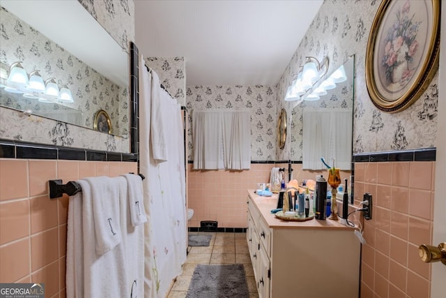 bathroom with vanity, toilet, tile walls, and tile patterned floors