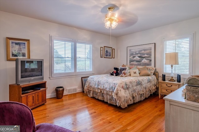 bedroom with multiple windows, ceiling fan, and light hardwood / wood-style floors