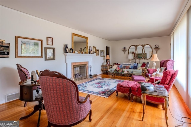 living room with wood-type flooring and a tile fireplace