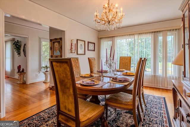 dining space featuring hardwood / wood-style flooring and an inviting chandelier