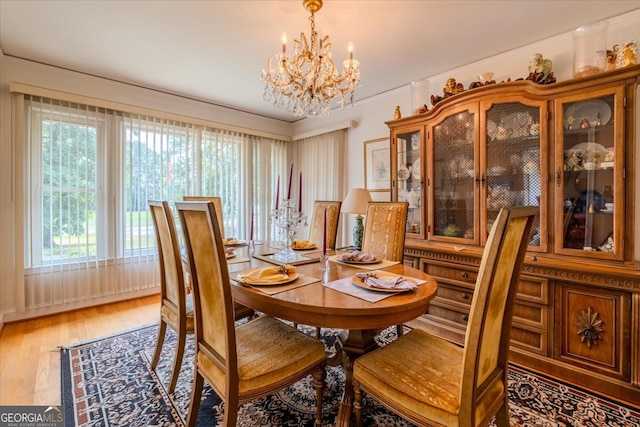 dining room featuring an inviting chandelier, plenty of natural light, and wood-type flooring