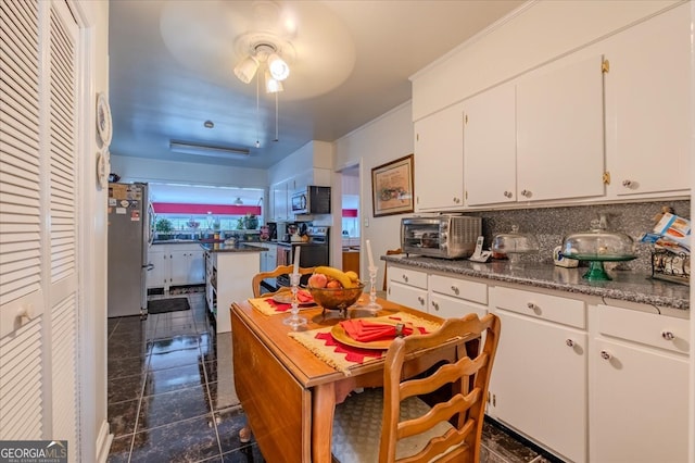 kitchen featuring ceiling fan, backsplash, stainless steel appliances, and white cabinets