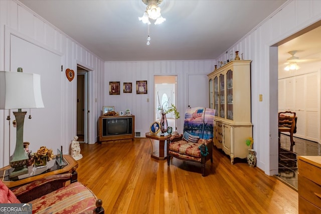 living room with ceiling fan, light hardwood / wood-style floors, and ornamental molding