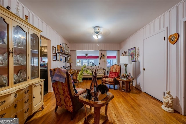 living area with ceiling fan and light hardwood / wood-style flooring