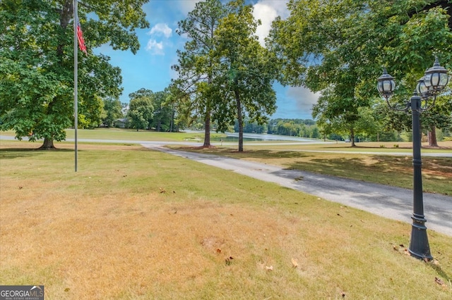 surrounding community featuring a water view and a lawn