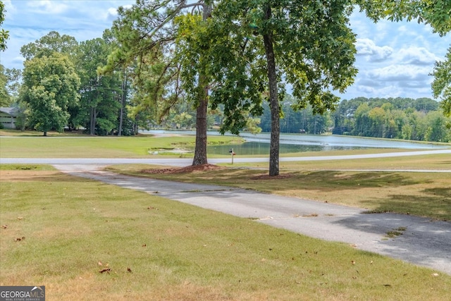 view of property's community with a water view and a yard