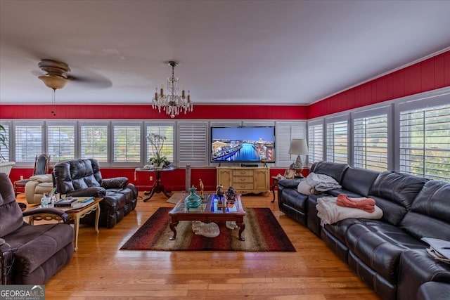 living room featuring ceiling fan with notable chandelier and hardwood / wood-style floors