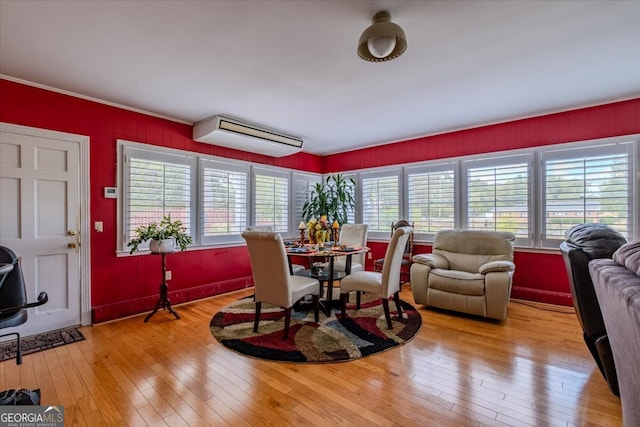 dining space featuring light wood-type flooring and a wall mounted AC