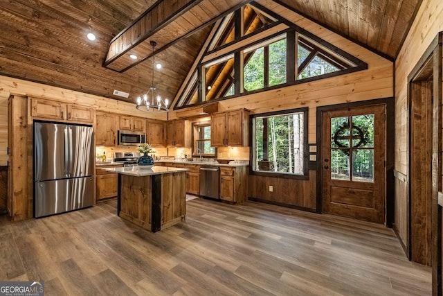 kitchen with a wealth of natural light, a kitchen island, stainless steel appliances, and wooden ceiling