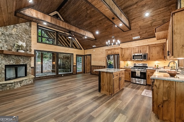 kitchen featuring wood ceiling, stainless steel appliances, a center island, sink, and dark wood-type flooring