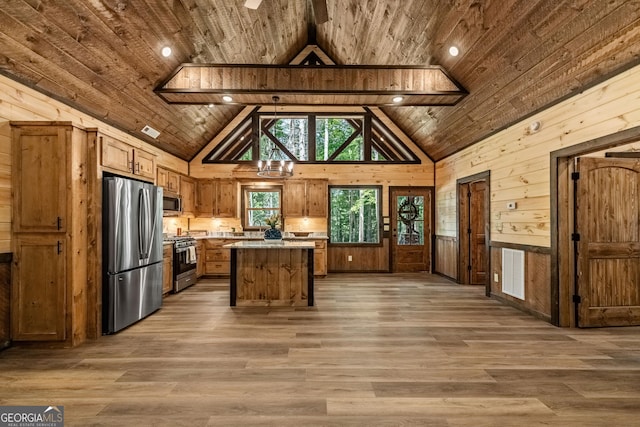 kitchen with a kitchen island, stainless steel appliances, wood-type flooring, and wooden ceiling