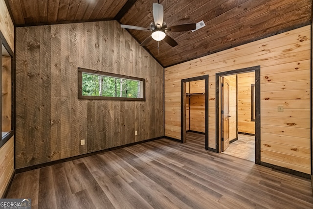 unfurnished room with wood walls, wood ceiling, hardwood / wood-style flooring, ceiling fan, and vaulted ceiling with beams