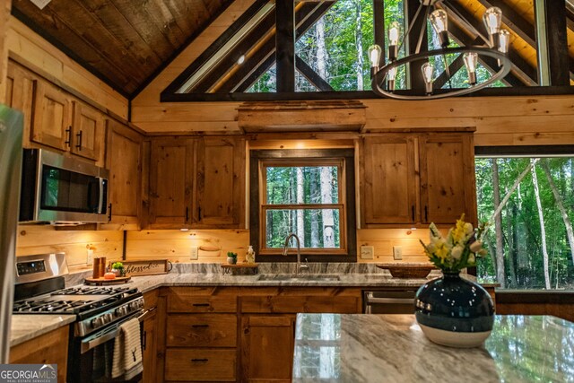 kitchen with a notable chandelier, stainless steel appliances, sink, light stone countertops, and wooden ceiling