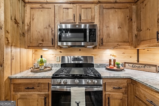 kitchen featuring stainless steel appliances and light stone countertops