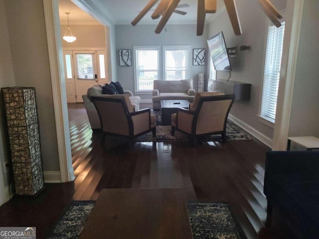 living room featuring beam ceiling, dark hardwood / wood-style flooring, ceiling fan, and ornamental molding