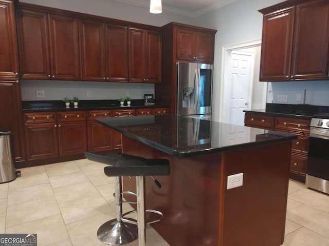 kitchen featuring a center island, stainless steel fridge, crown molding, a breakfast bar, and range