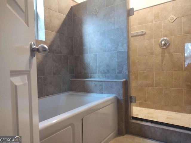 bathroom featuring independent shower and bath