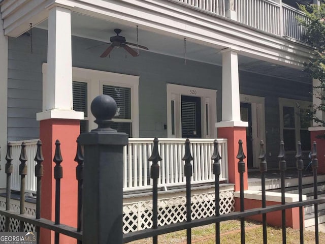 view of gate with ceiling fan and covered porch