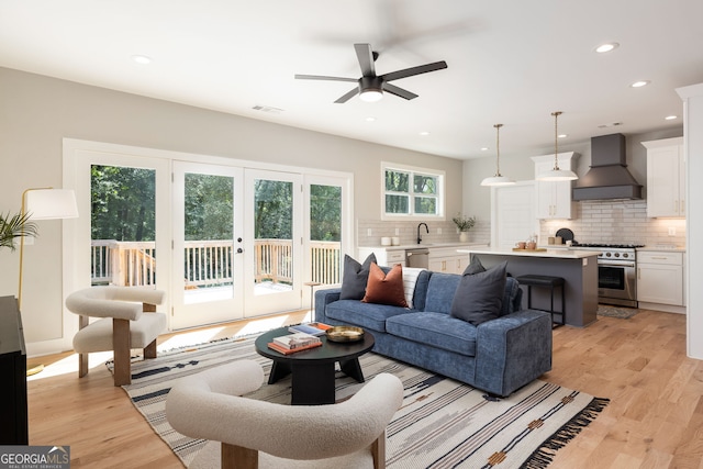 living room with light hardwood / wood-style flooring and ceiling fan