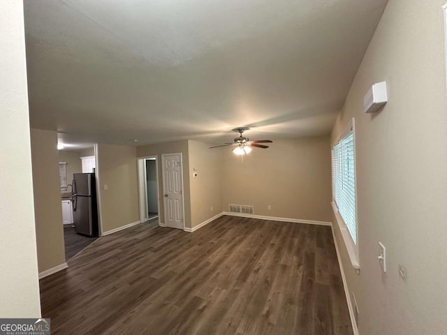 unfurnished living room featuring ceiling fan and dark hardwood / wood-style flooring