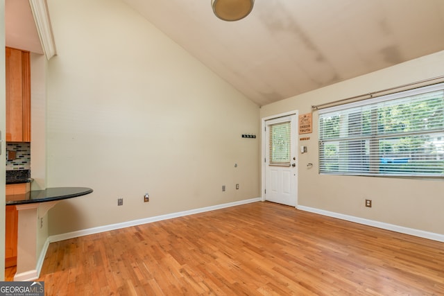 entryway with high vaulted ceiling and light hardwood / wood-style floors