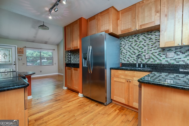 kitchen featuring tasteful backsplash, sink, light hardwood / wood-style floors, lofted ceiling, and stainless steel fridge with ice dispenser