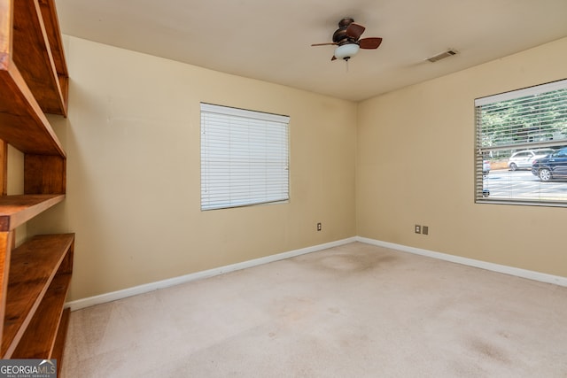 carpeted spare room featuring ceiling fan