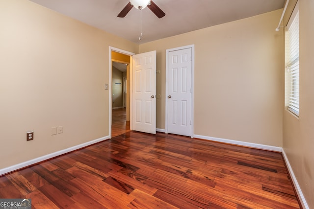 unfurnished bedroom featuring dark wood-type flooring and ceiling fan