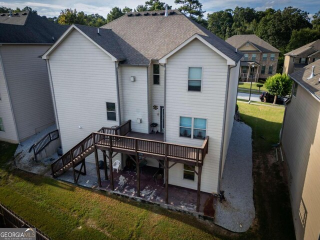 back of property with a yard and a patio