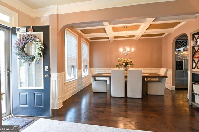 dining space with ornamental molding, dark wood-type flooring, coffered ceiling, and a wealth of natural light