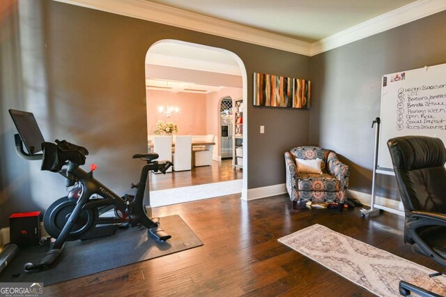 exercise room with crown molding and hardwood / wood-style floors