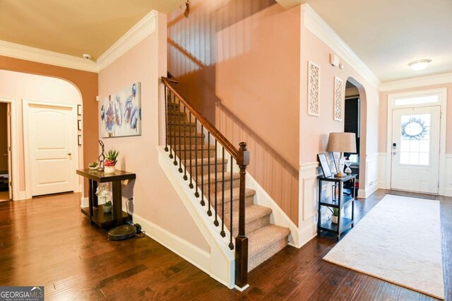 entrance foyer featuring dark wood-type flooring and ornamental molding