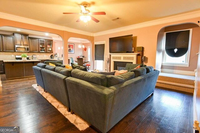 living room featuring ornamental molding, dark hardwood / wood-style flooring, and ceiling fan