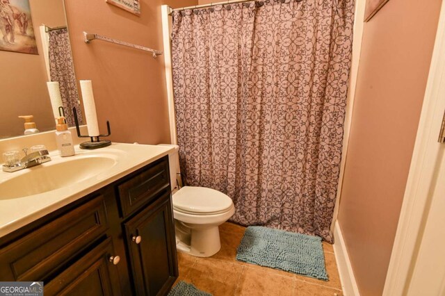 bathroom with tile patterned flooring, vanity, toilet, and walk in shower