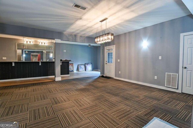 interior space with dark carpet and a notable chandelier